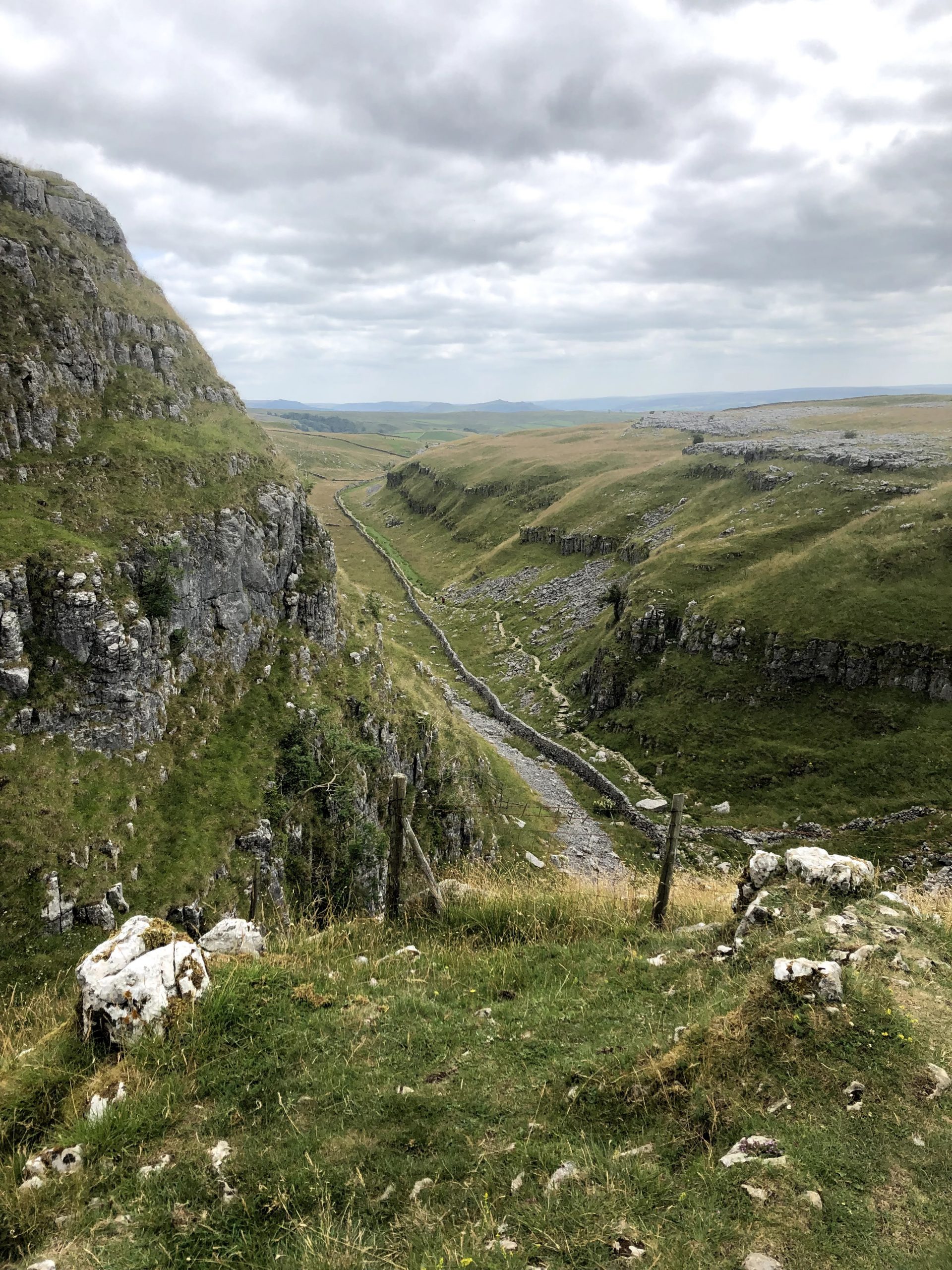 Beautiful Malham Cove trail with rocky crags and valley