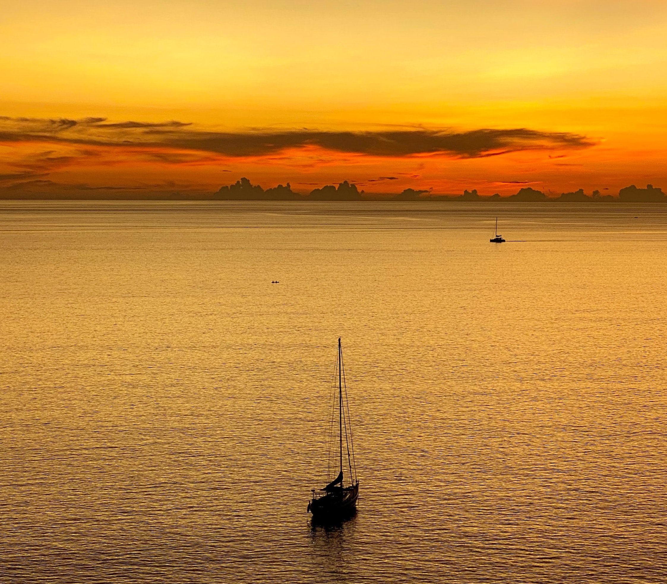 Boat at sunset sailing from Nai Harn Beach