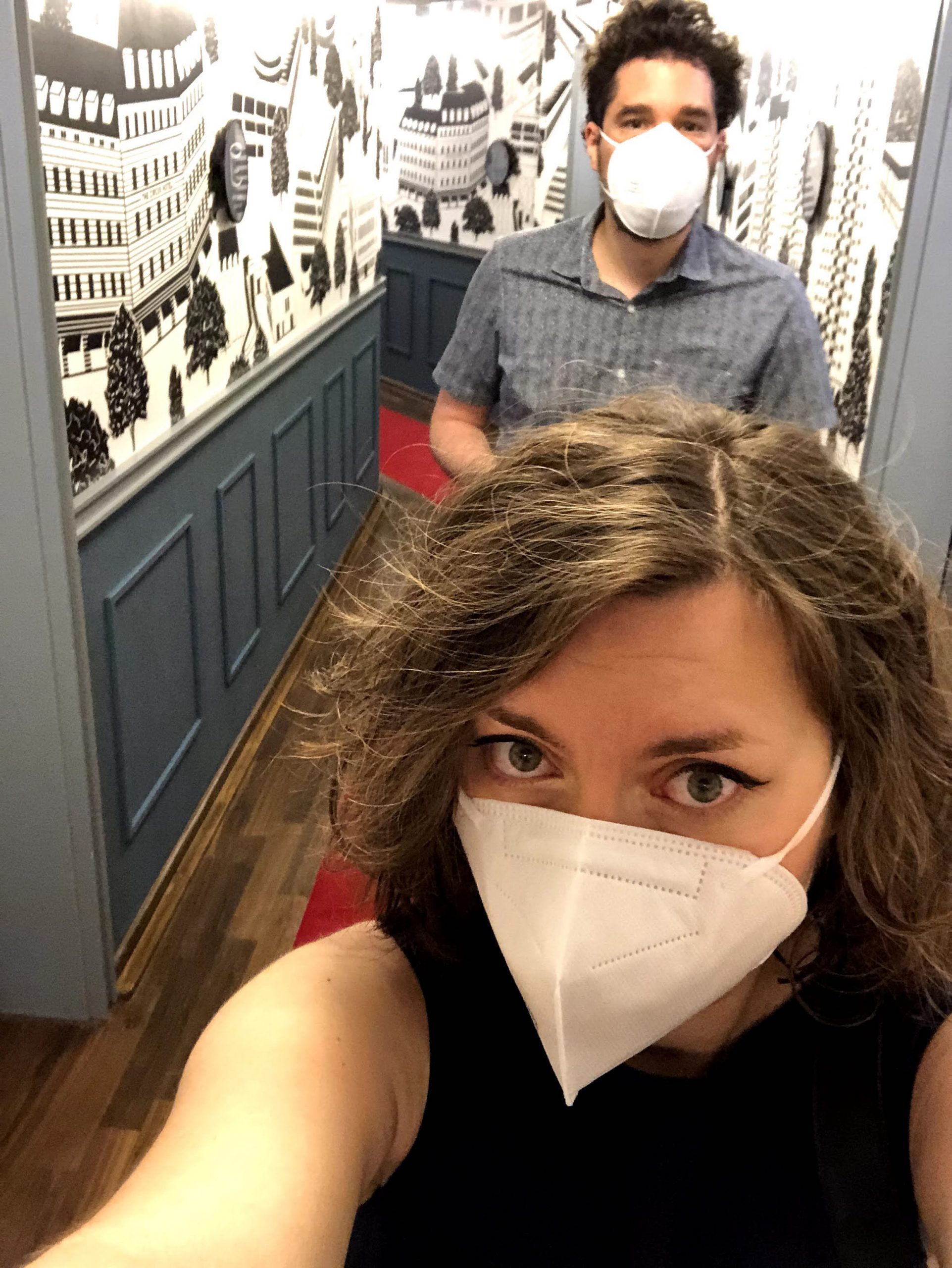Cory and G walking in the hotel corridor with masks on - circus hotel
