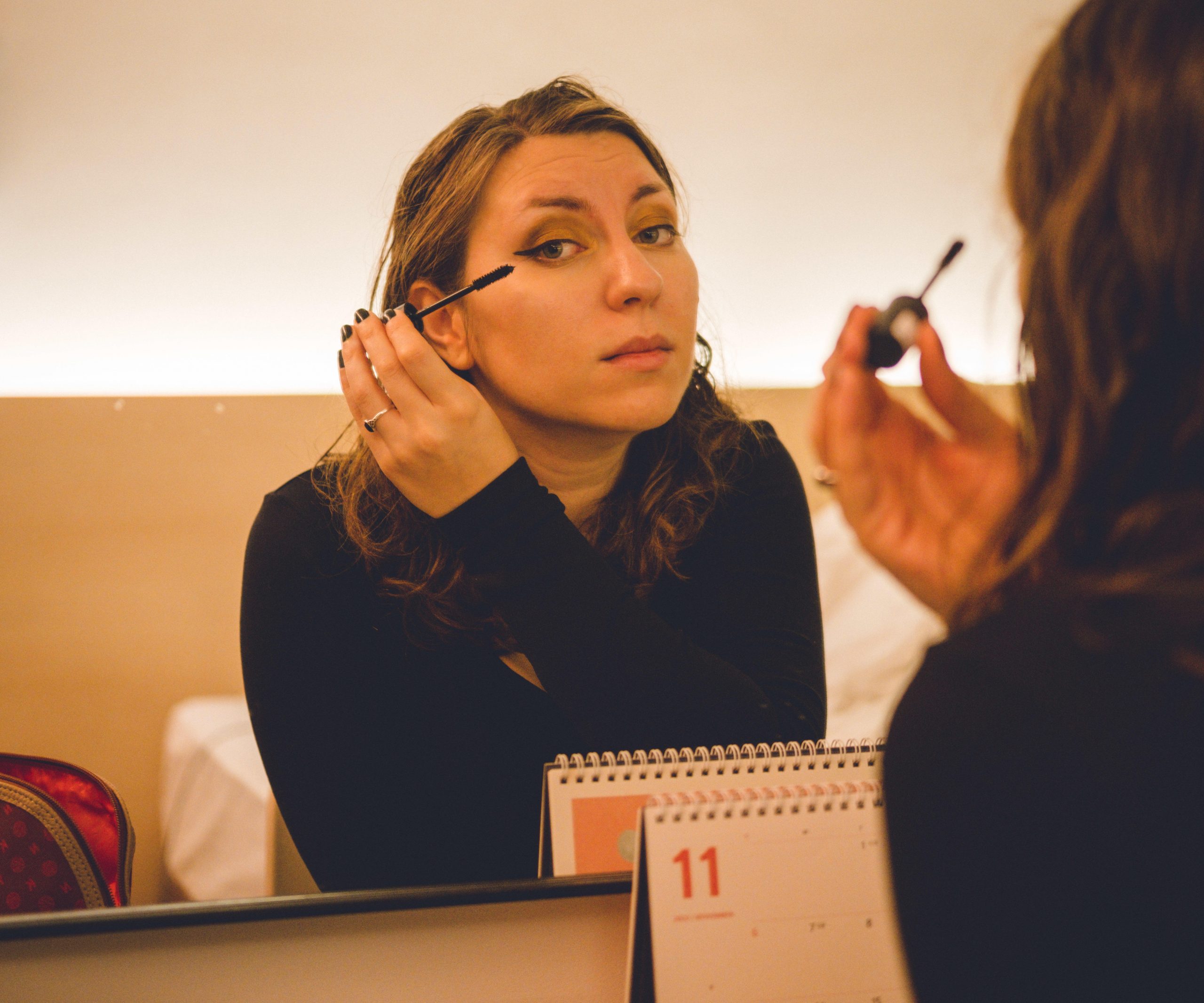 Cory applying travel makeup in the mirror Cory applying travel makeup in the mirror