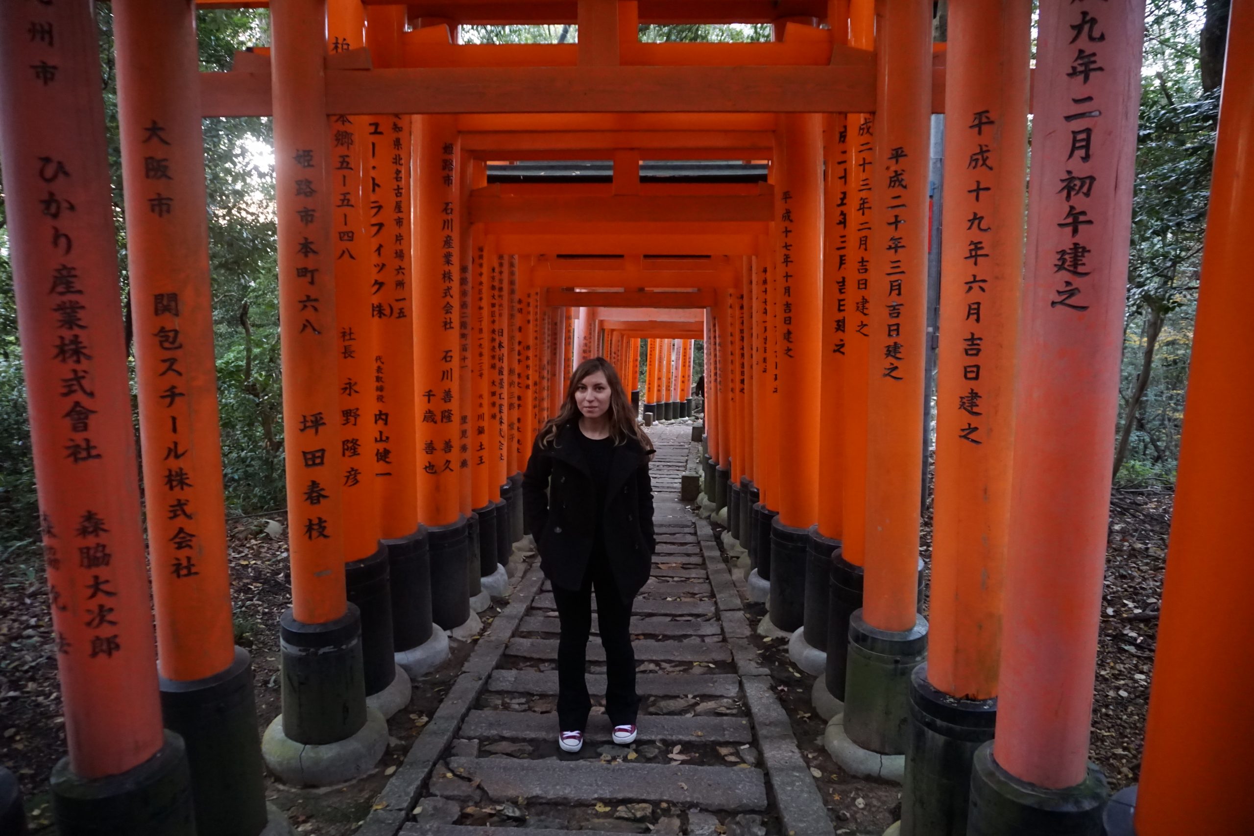 Cory from You Could Travel climbing stairs during the hike at Fushimi Inari Shrine.