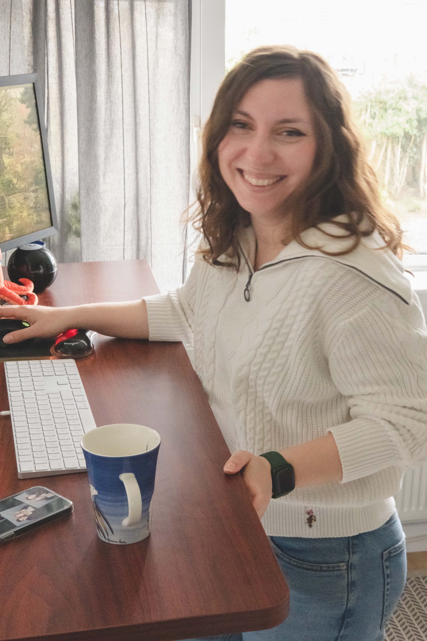 Cory smiling and happy with her health benefits from her standing desk