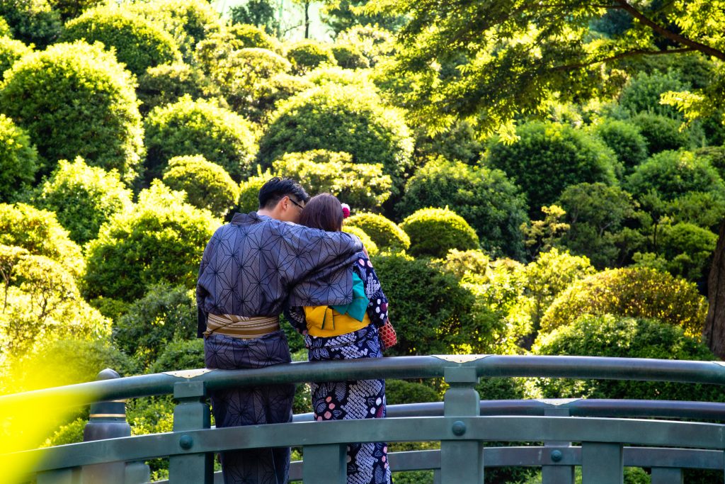 A young couple wearing kimonos on a bridge in Japan