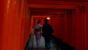 A couple walking through the torii gates in fushimi inari shrine