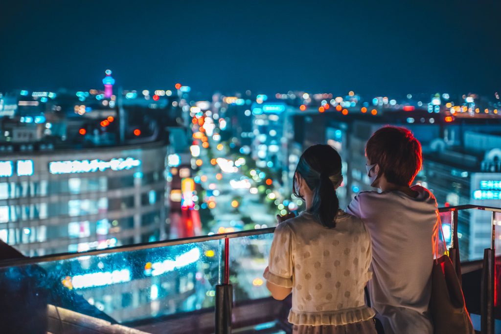 Couple looking at the neon lit night skyline of Tokyo