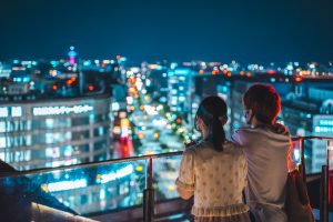 Couple looking at the neon lit night skyline of Tokyo