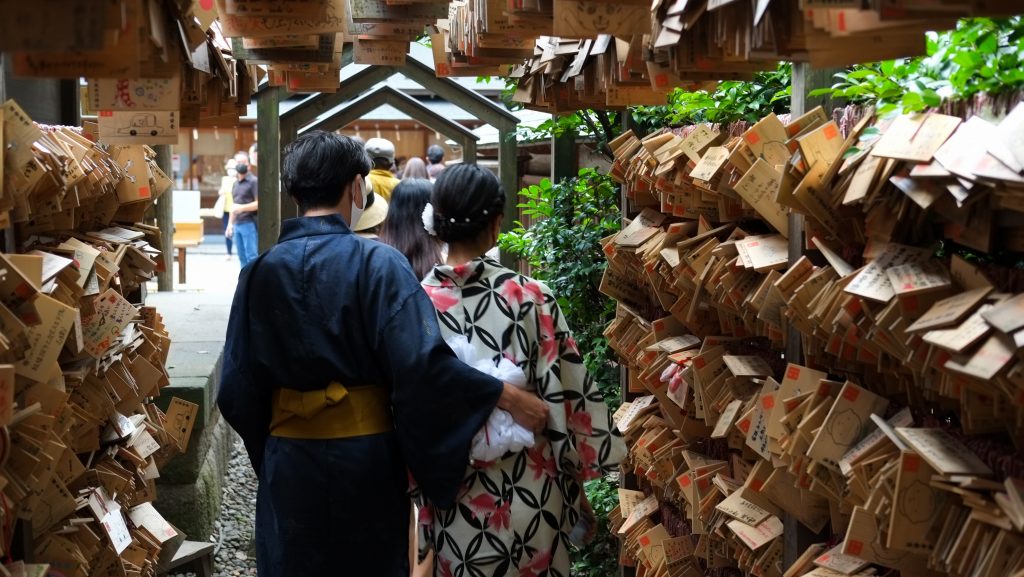 Couple making a wish with an ema at a japanese temple
