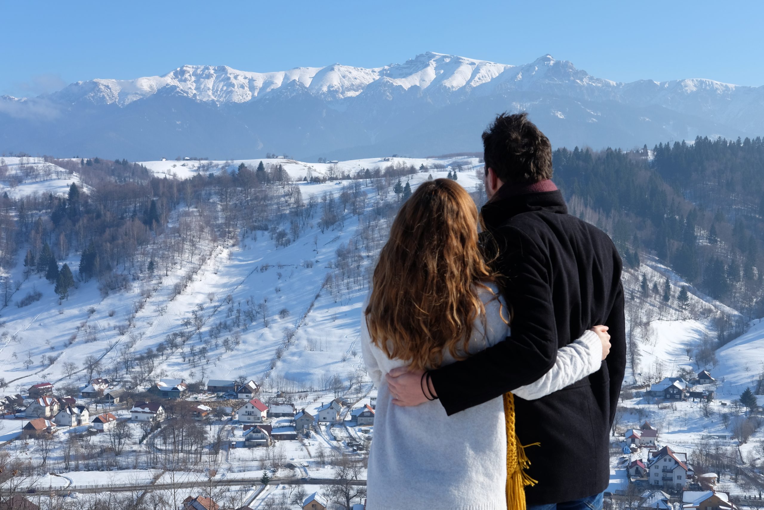 Cuplu de la You Could Travel admira muntii de la poiana brasov iarna