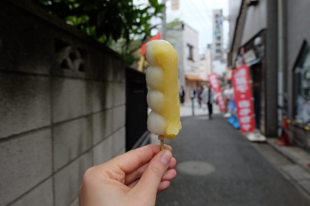 Cory holding a dango with yuzu paste on them in Shibamata, Tokyo