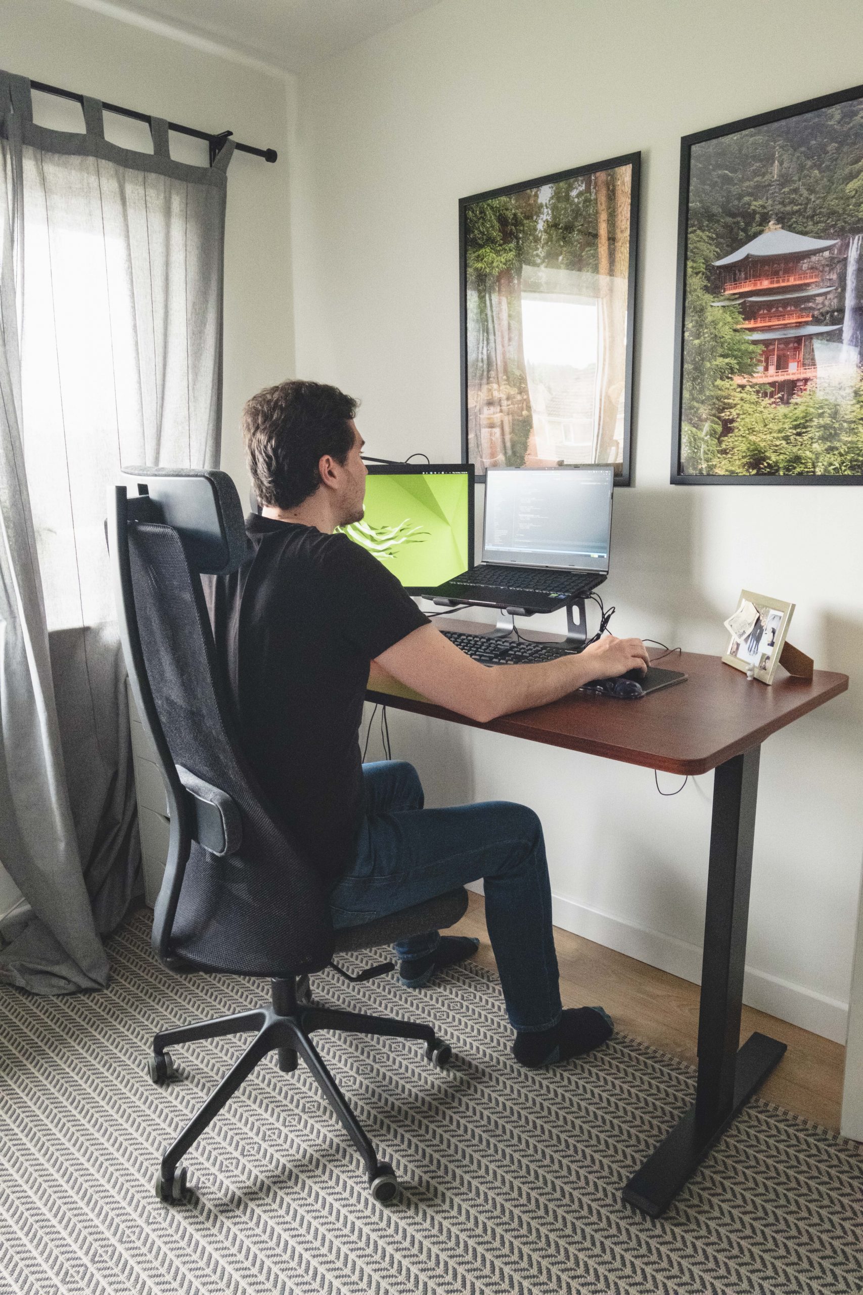 Greg sitting down at his Flexispot desk