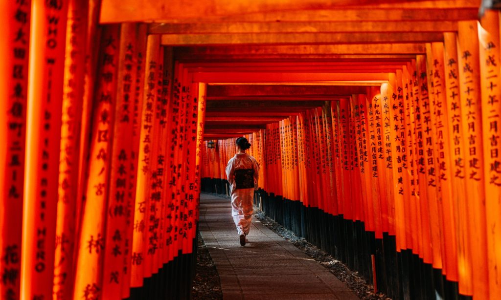 Geisha Walking through the torii gates at Fushimi Inari Shrine, Kyoto