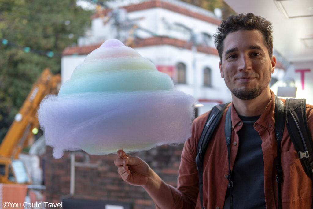 Candy Floss Japan Greg from You Could Travel holding a rainbow cotton candy from Totti candy factory in Tokyo