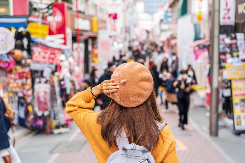 Woman traveler walking on the Takeshita street in Harajuku the center of teenage fashion and cosplay culture in Tokyo