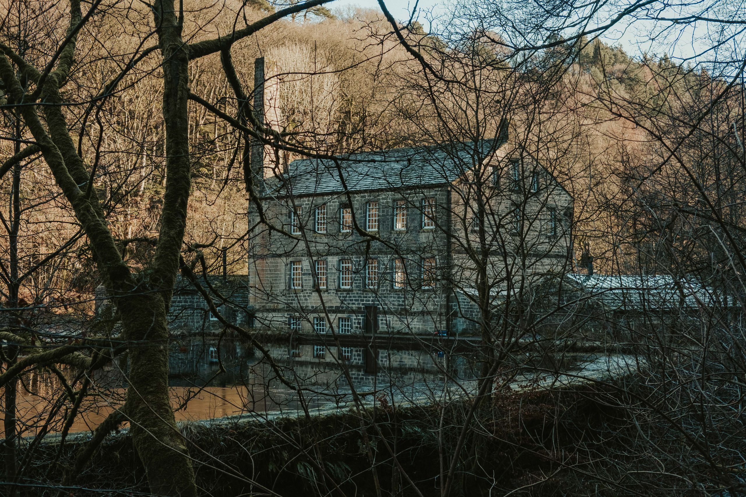 Hebden Bridge mill surrounded by trees in the middle of the winter