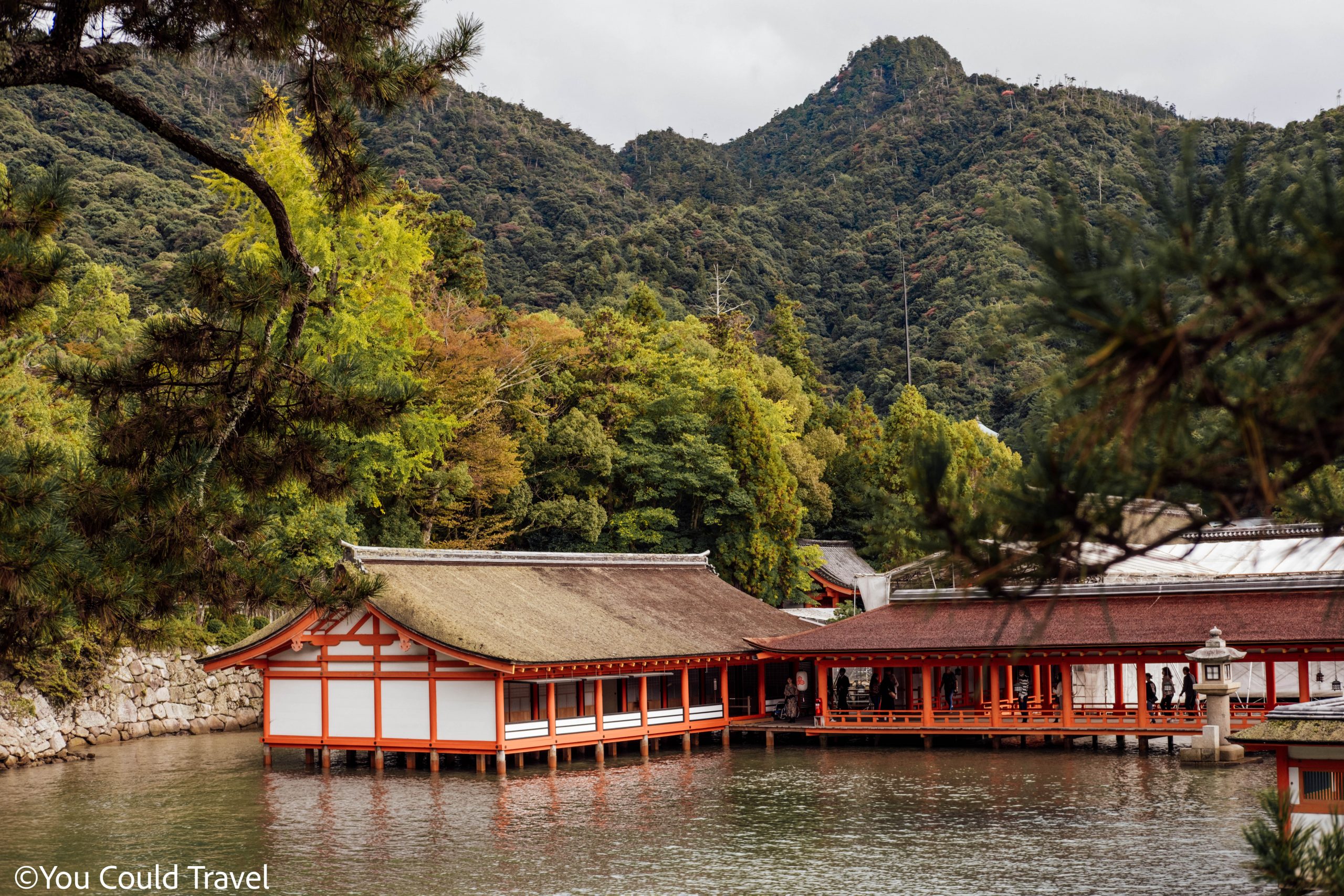 Itsukushima shrine main hall over water surrounded by nature