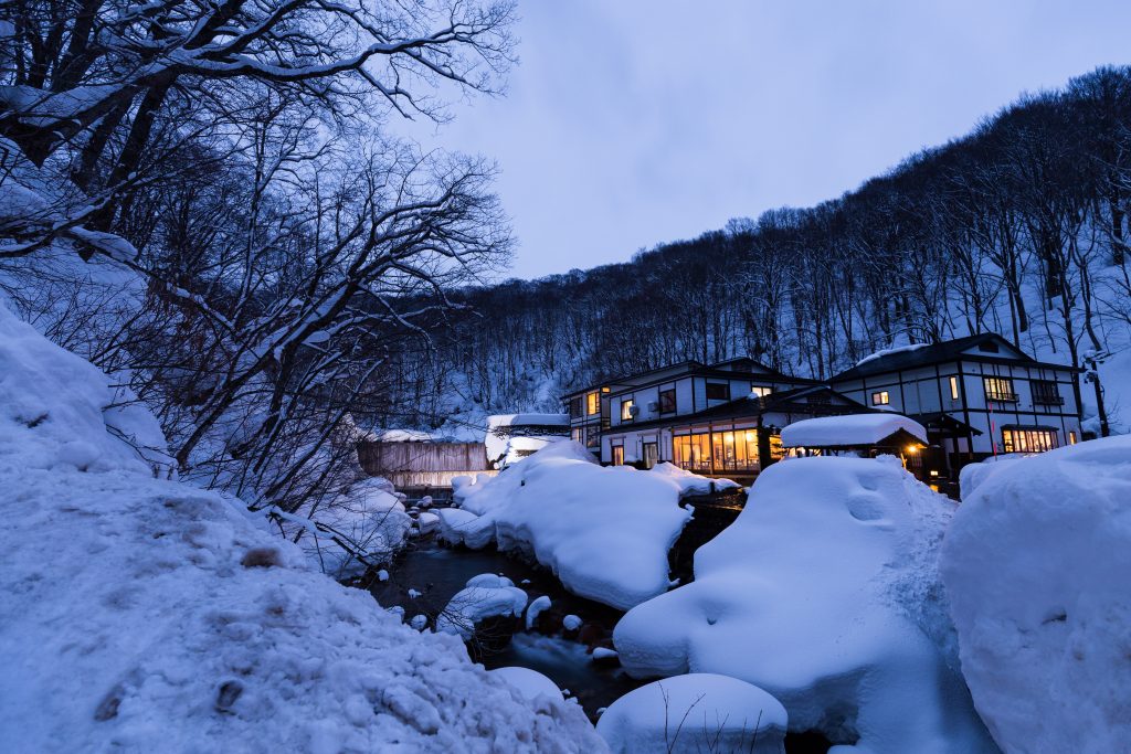 A ryokan with onsen during a snowy evening in Kyoto