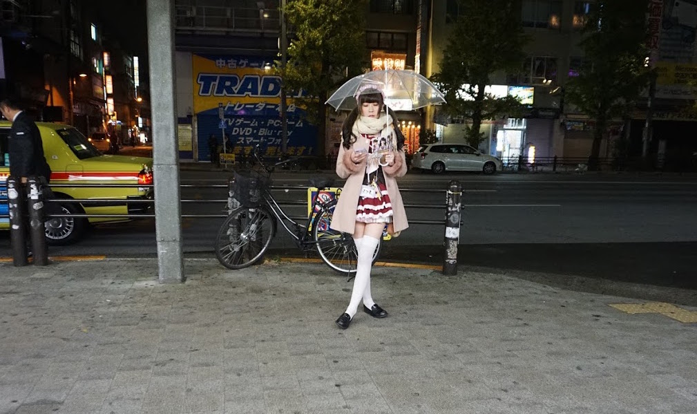 Woman in Japan trying to get customers into maid cafes in Akihabara