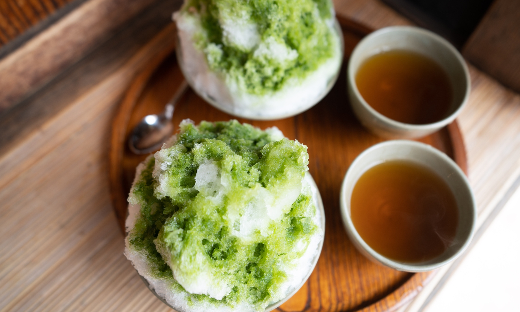 Matcha Kakigori served mainly in the summer with a side of tea in Japan