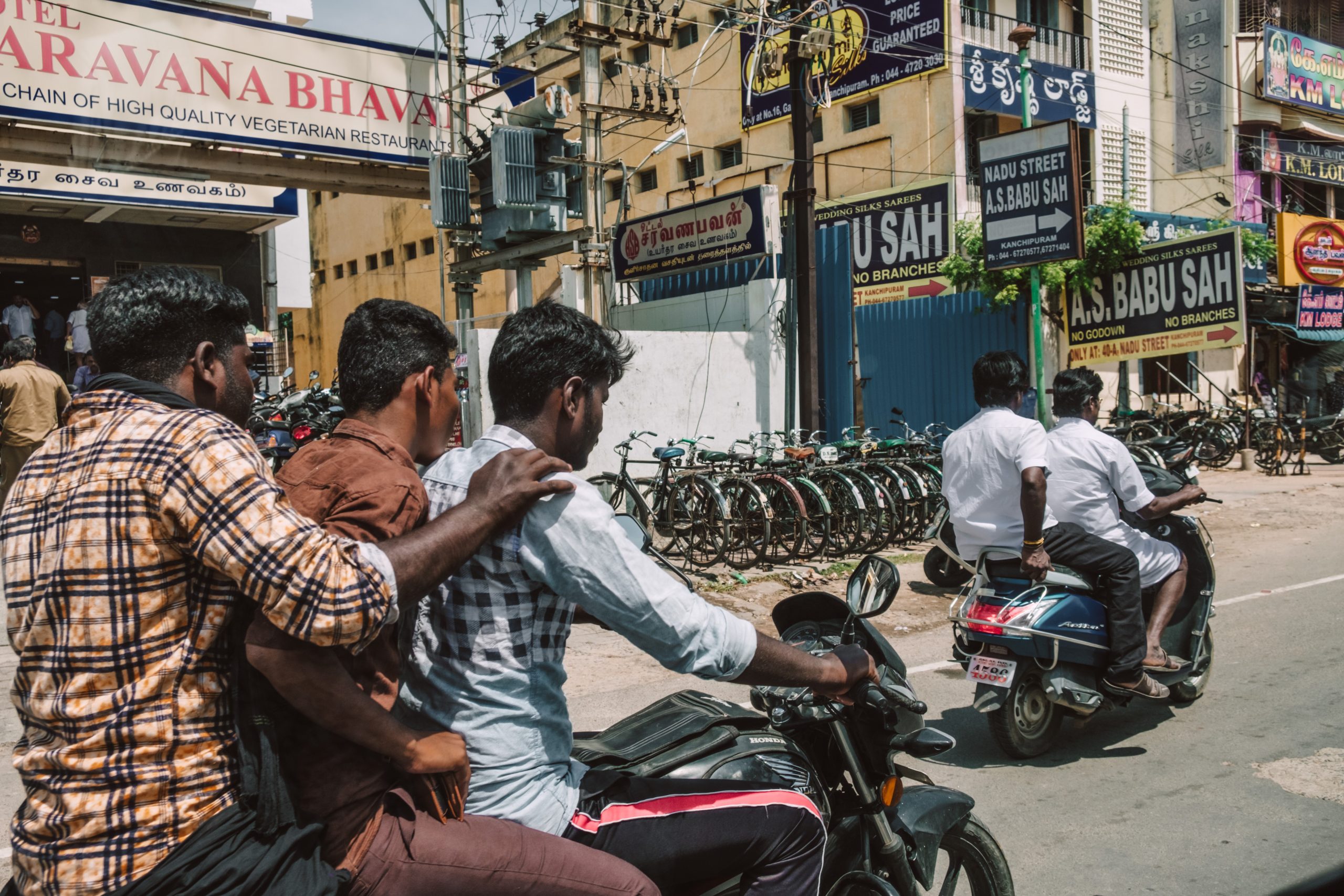 Men dressed casual on scooters in India