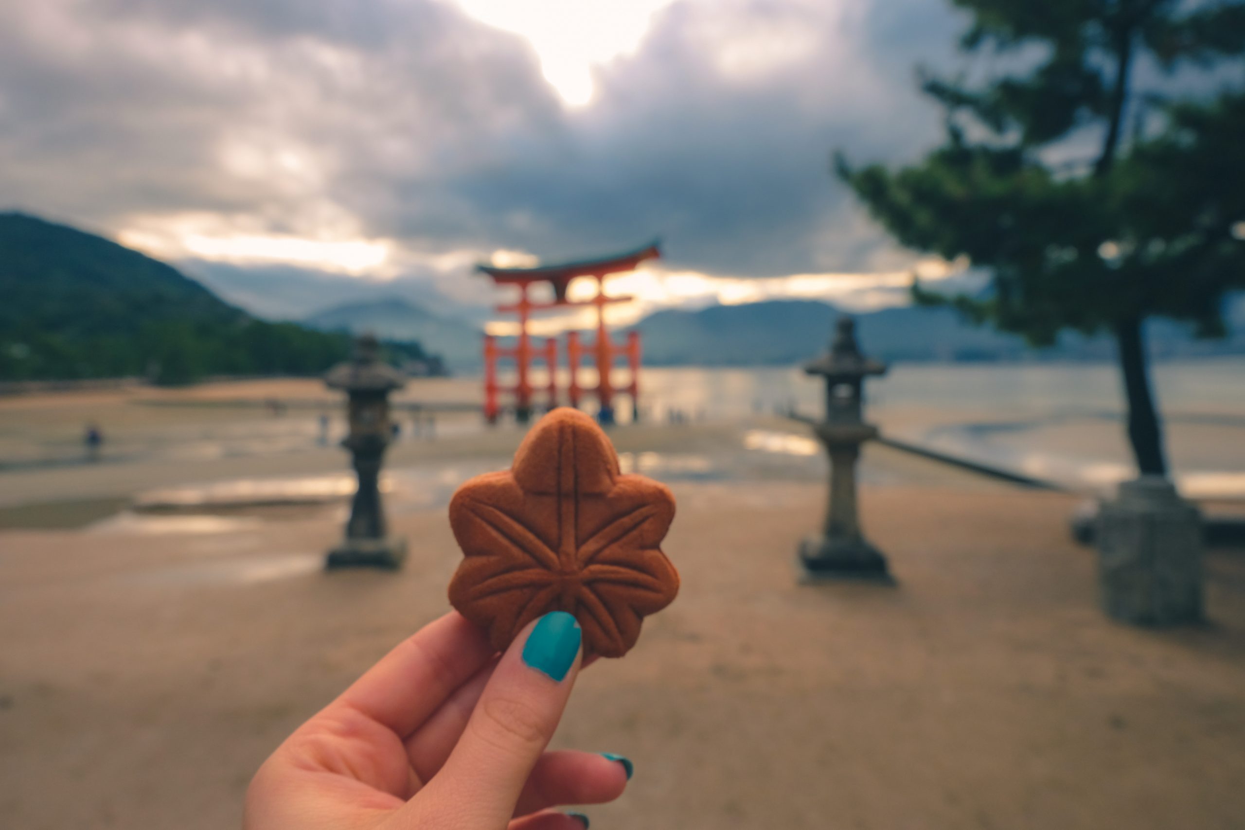 Cory from You Could Travel enjoying a momiji manjū on miyajima island