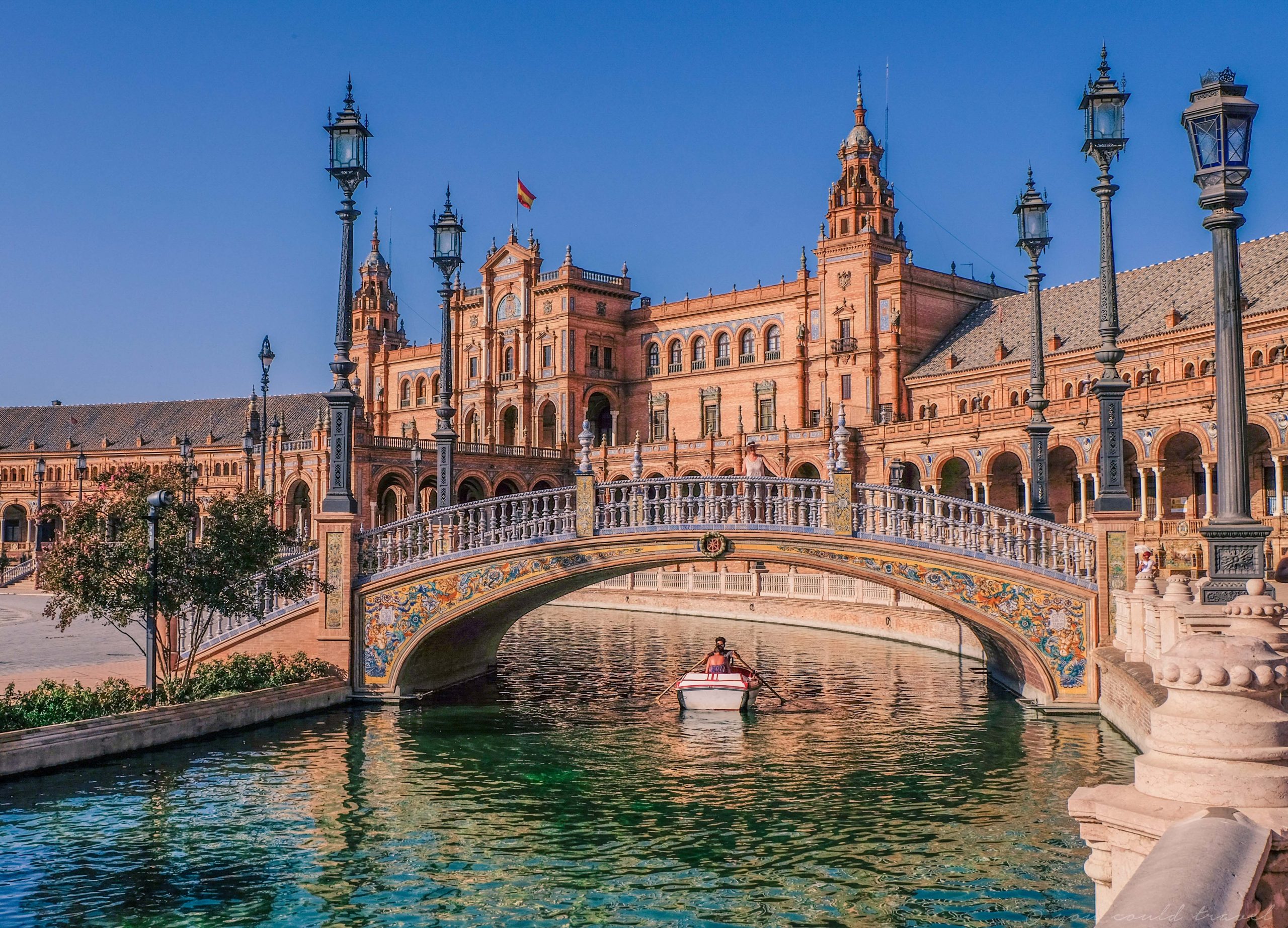 Couple rowing on a boat on the river in Seville towards plaza de espana