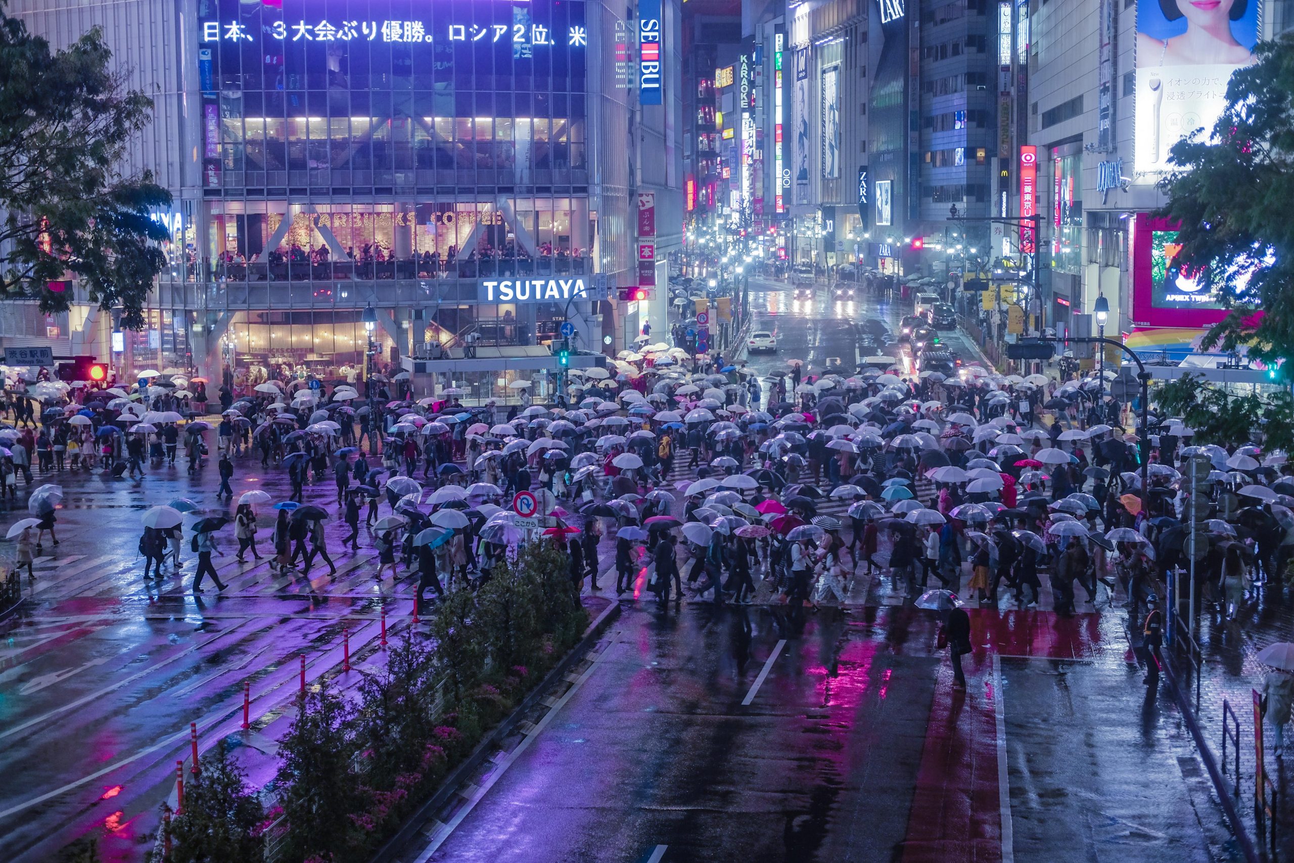 People crossing the famed Shibuya Crossing at night People crossing the famed Shibuya Crossing at night