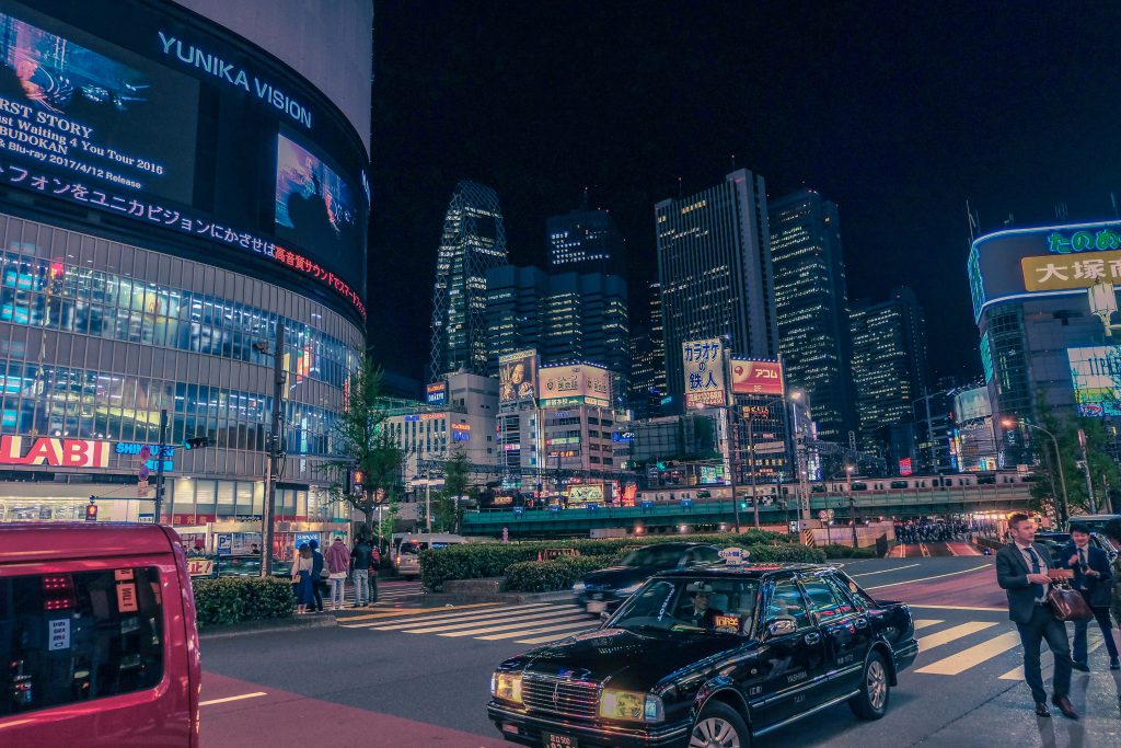 Shinjuku street at night, with its skyscrapers in the background