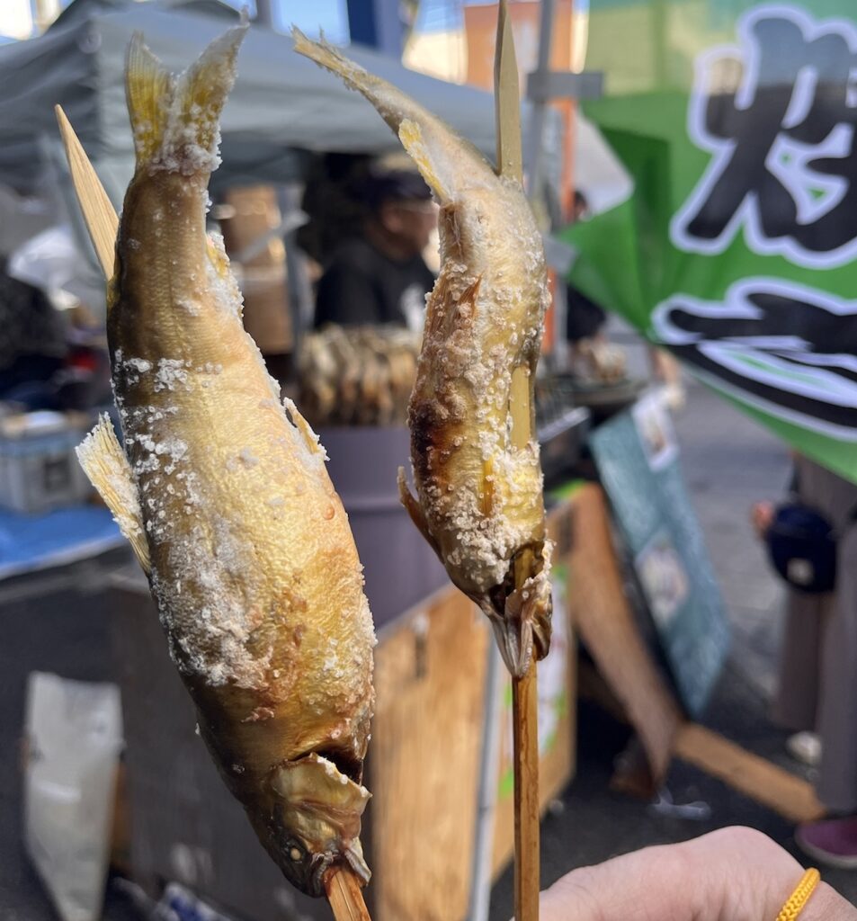 Fish grilling at the table Shioyaki is grilled fish with salt on skewers as street food in Japan