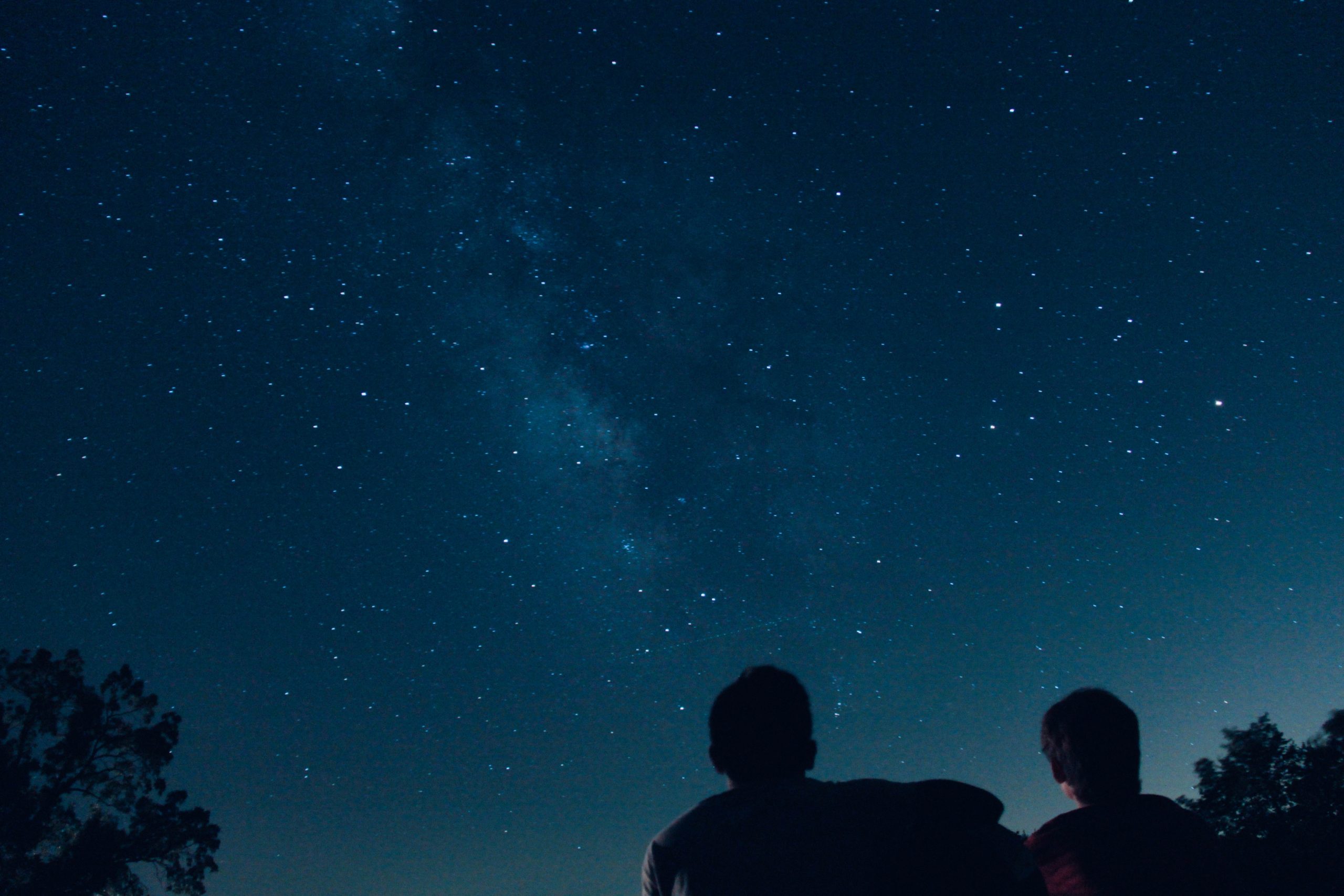 Two people stargazing - dark sky reserve England Two people stargazing - dark sky reserve England