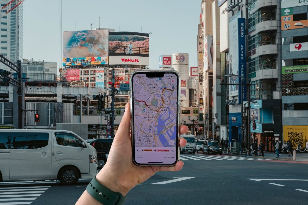Cory holding her phone in front of Shibuya area, showcasing useful travel apps for Japan