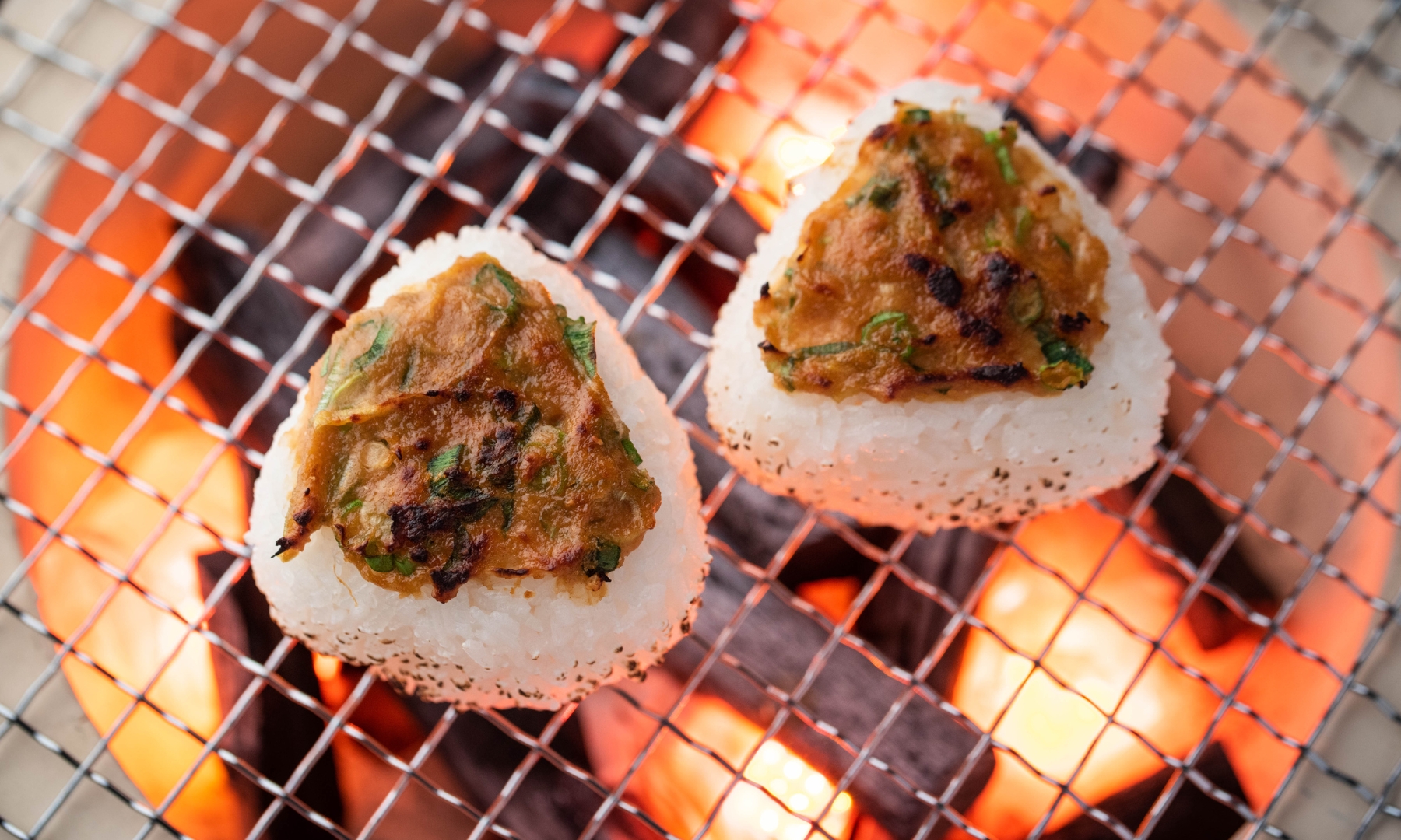 Yaki onigiri with miso topping being prepared on a grill