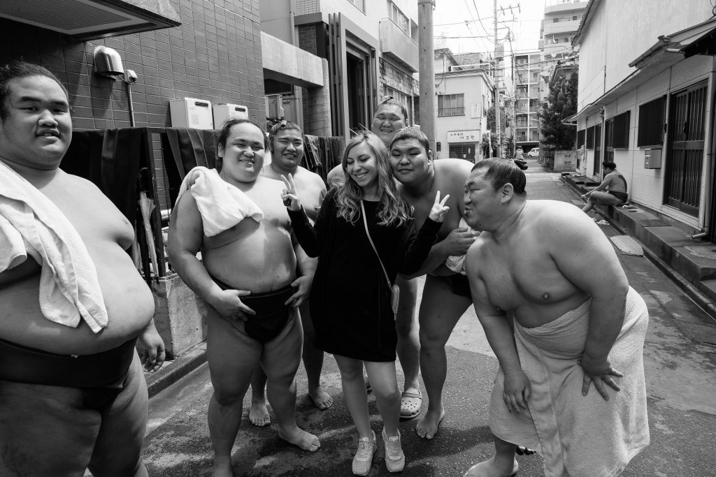 Cory from You Could Travel surrounded by sumo players after a morning sumo practice